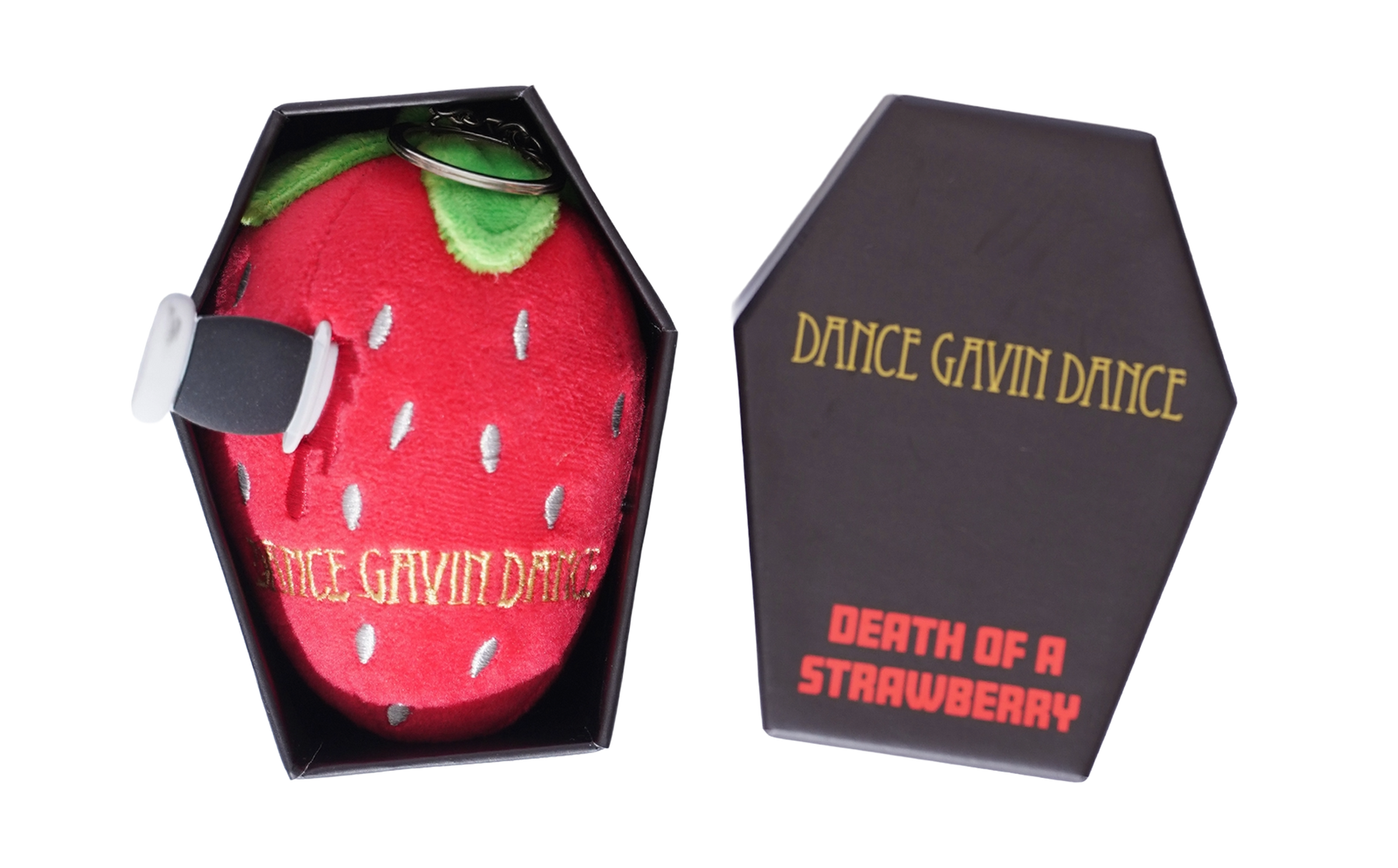A novelty plush strawberry toy with a knife handle attached, shown next to its black coffin-shaped packaging box on a white background.