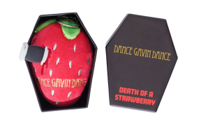 A novelty plush strawberry toy with a knife handle attached, shown next to its black coffin-shaped packaging box on a white background.