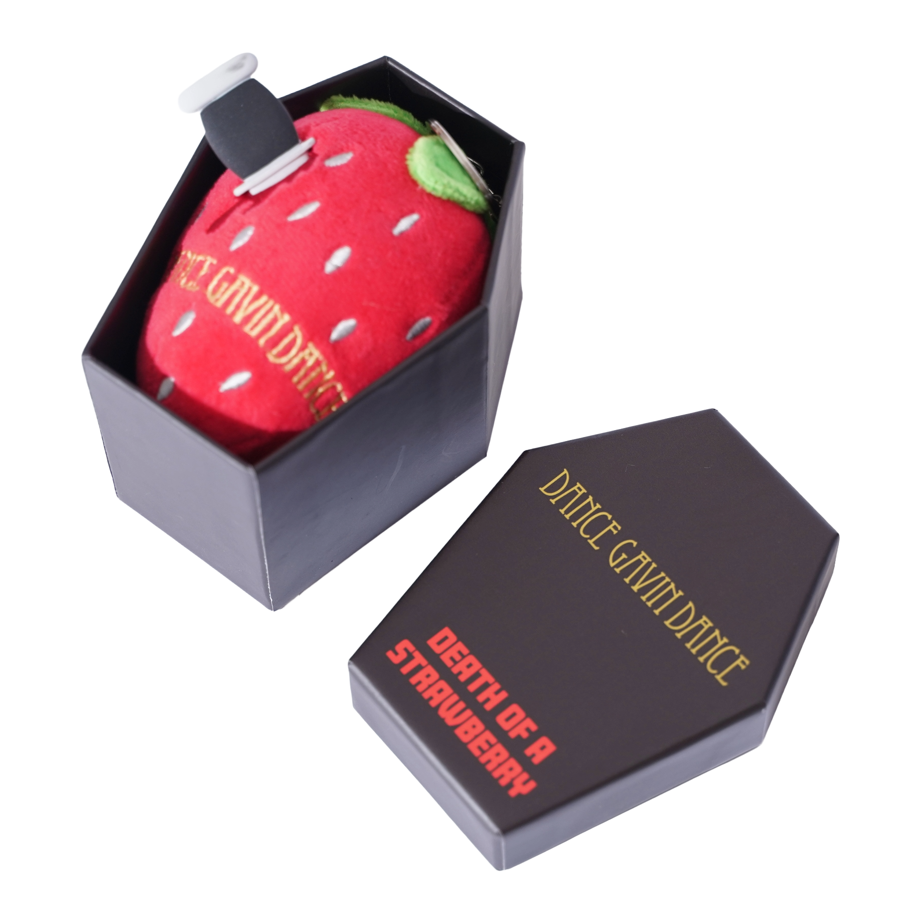 A novelty plush keychain shaped like a red strawberry, displayed inside a black coffin-shaped box next to its matching lid on a white background.
