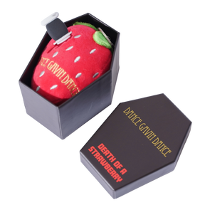 A novelty plush keychain shaped like a red strawberry, displayed inside a black coffin-shaped box next to its matching lid on a white background.