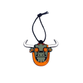 An enamel ornament in the shape of a bull's head with black horns and orange body, with a string for hanging.