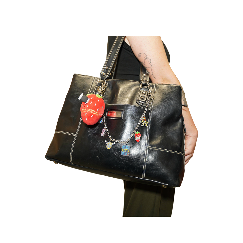 A black leather tote bag with silver-tone hardware and multiple charms, 